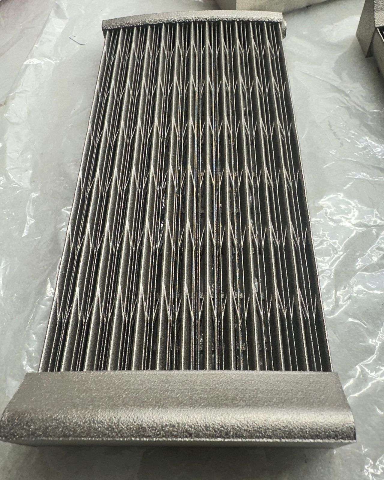 Electroless nickel plated finned part with closely spaced fins, on plastic sheet